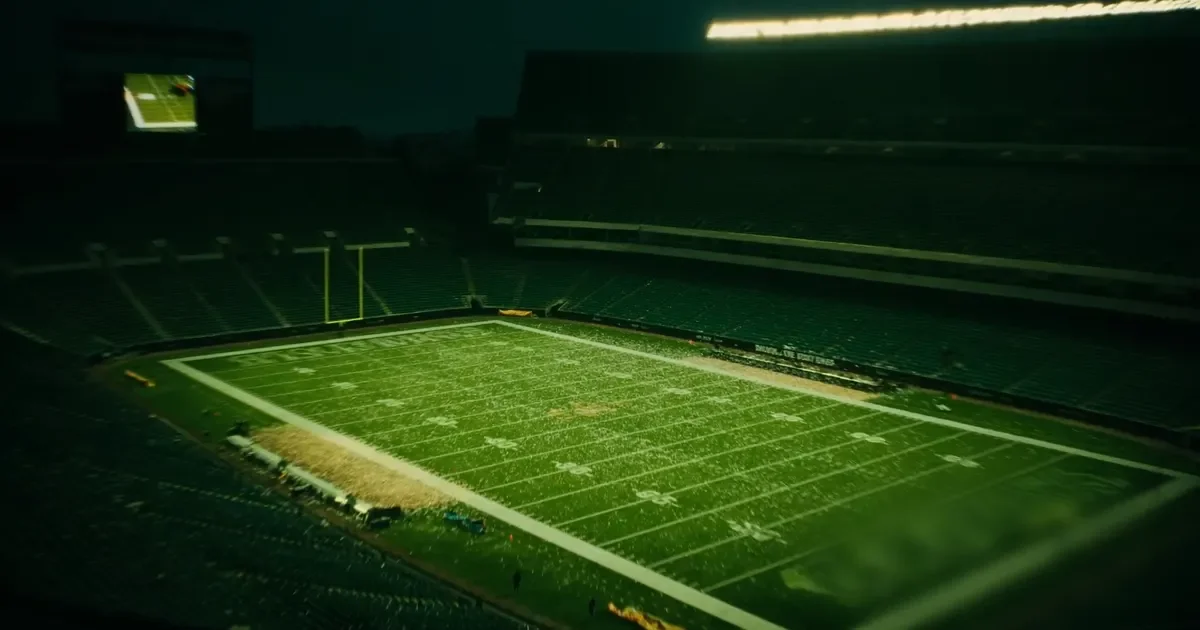 An empty American football stadium at dusk seen from the upper stands